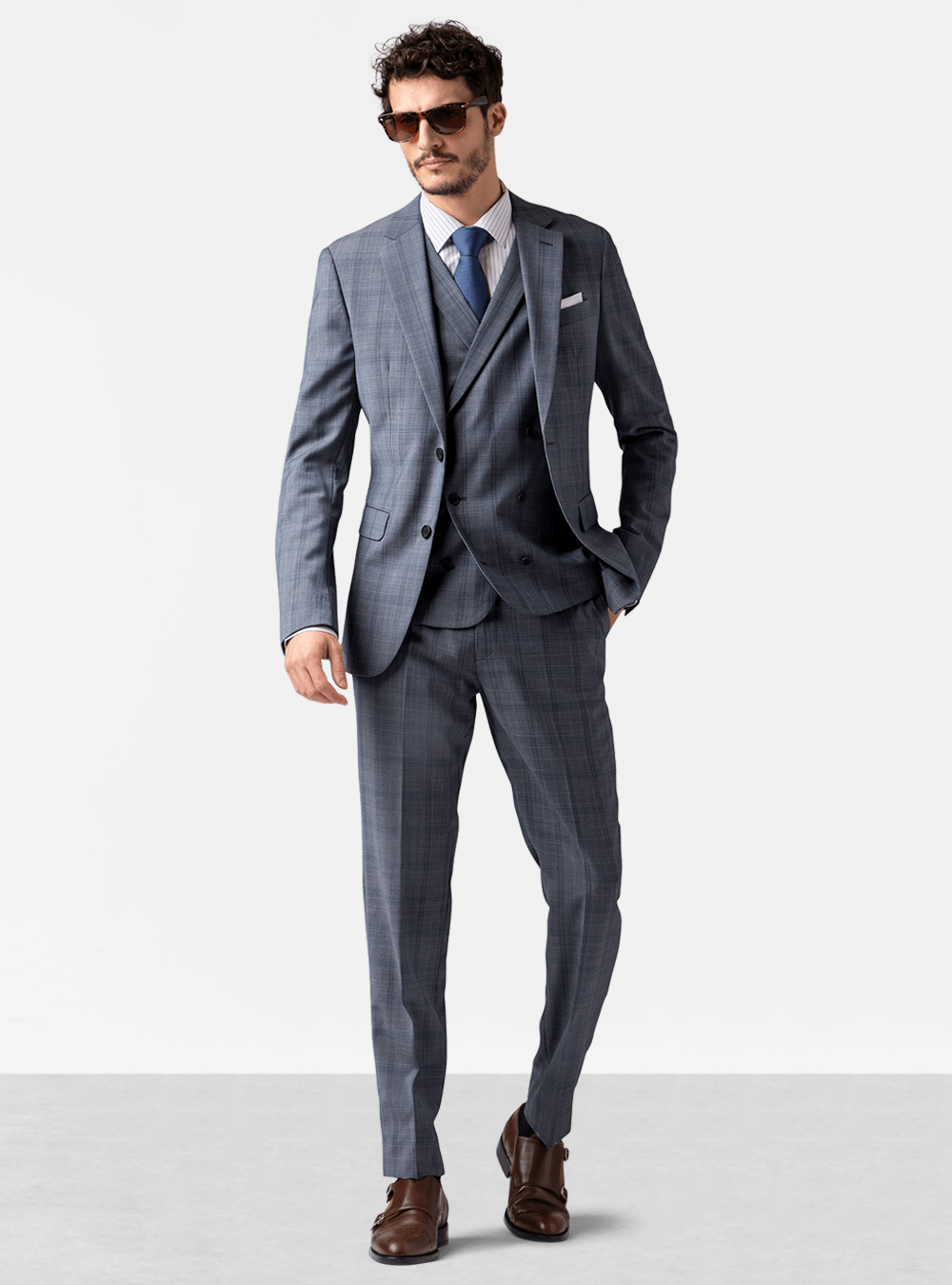Grey plaid three-piece suit, white striped dress shirt, blue tie and brown double monks