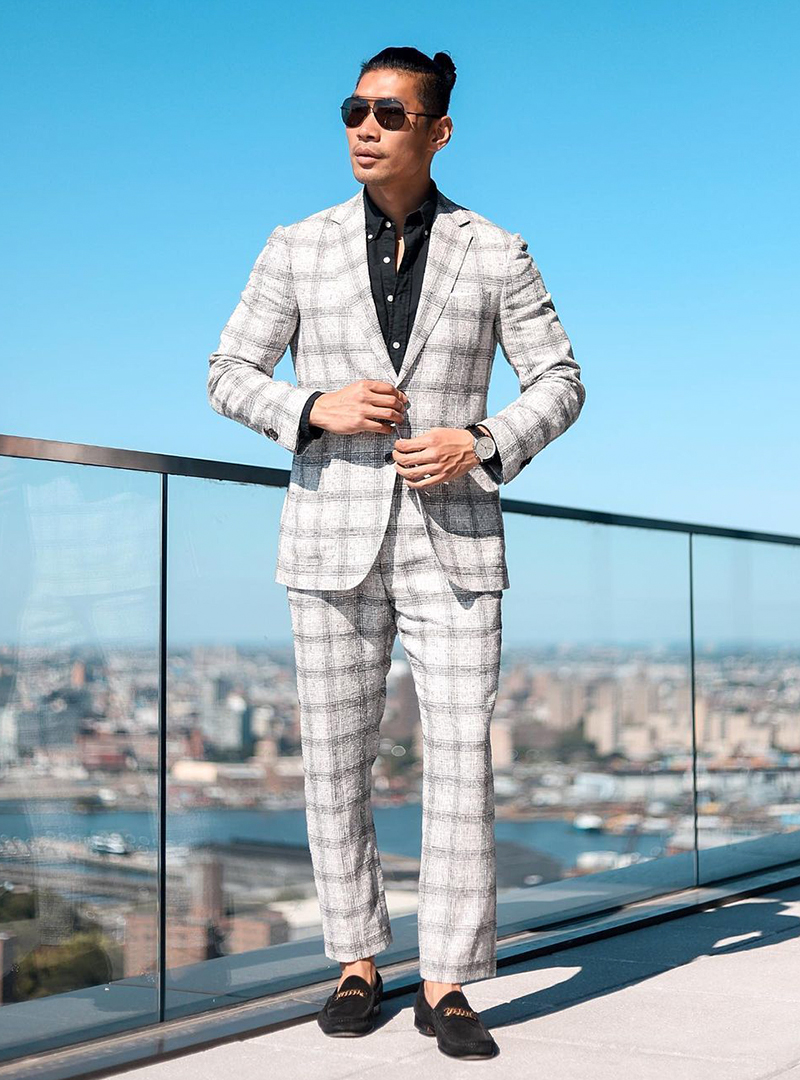 light-grey plaid suit, black shirt, and black loafers