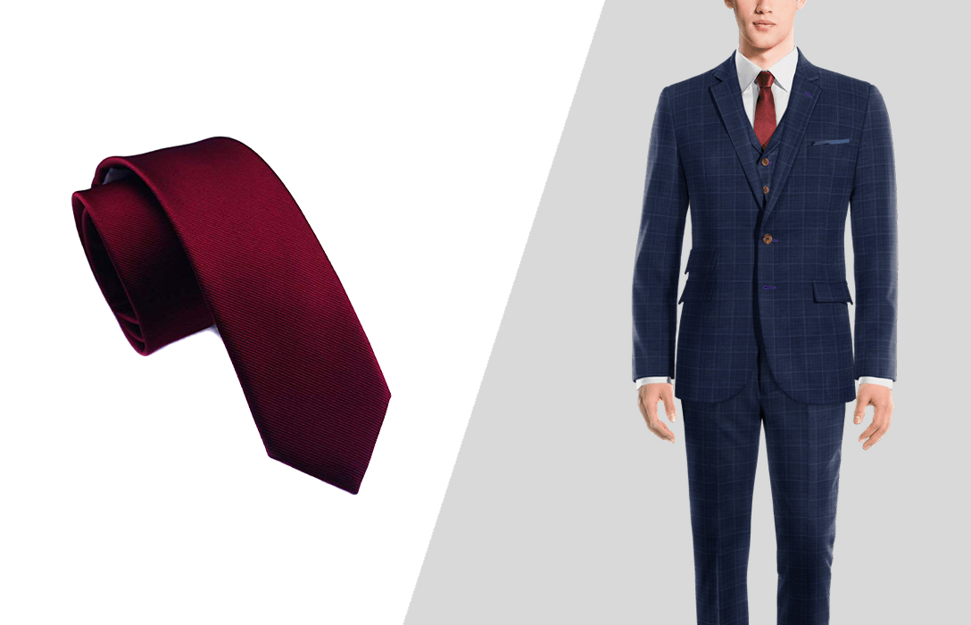 wearing a burgundy tie with a navy three-piece suit