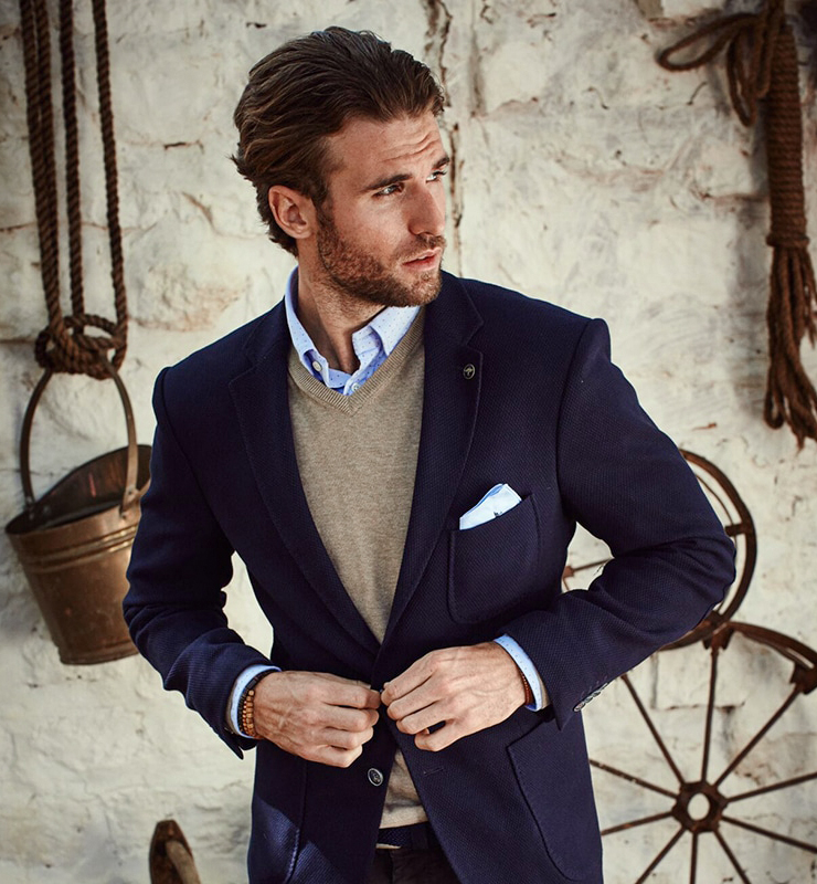 navy blazer with a tan v-neck sweater and blue patterned shirt