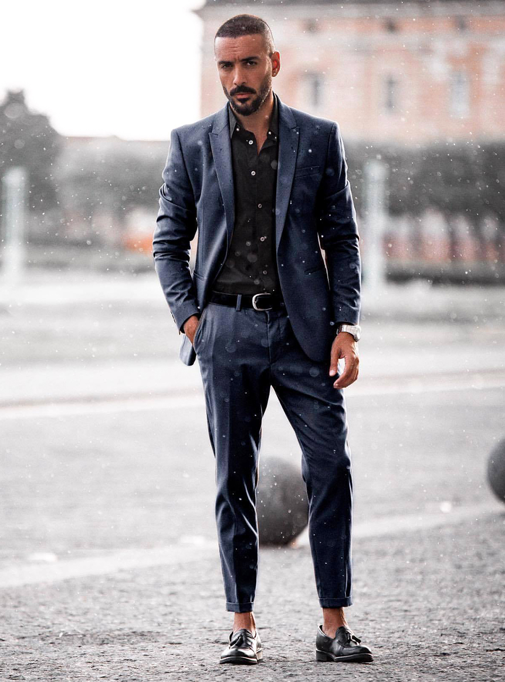 Navy blue suit, black dress shirt and black tassel loafers