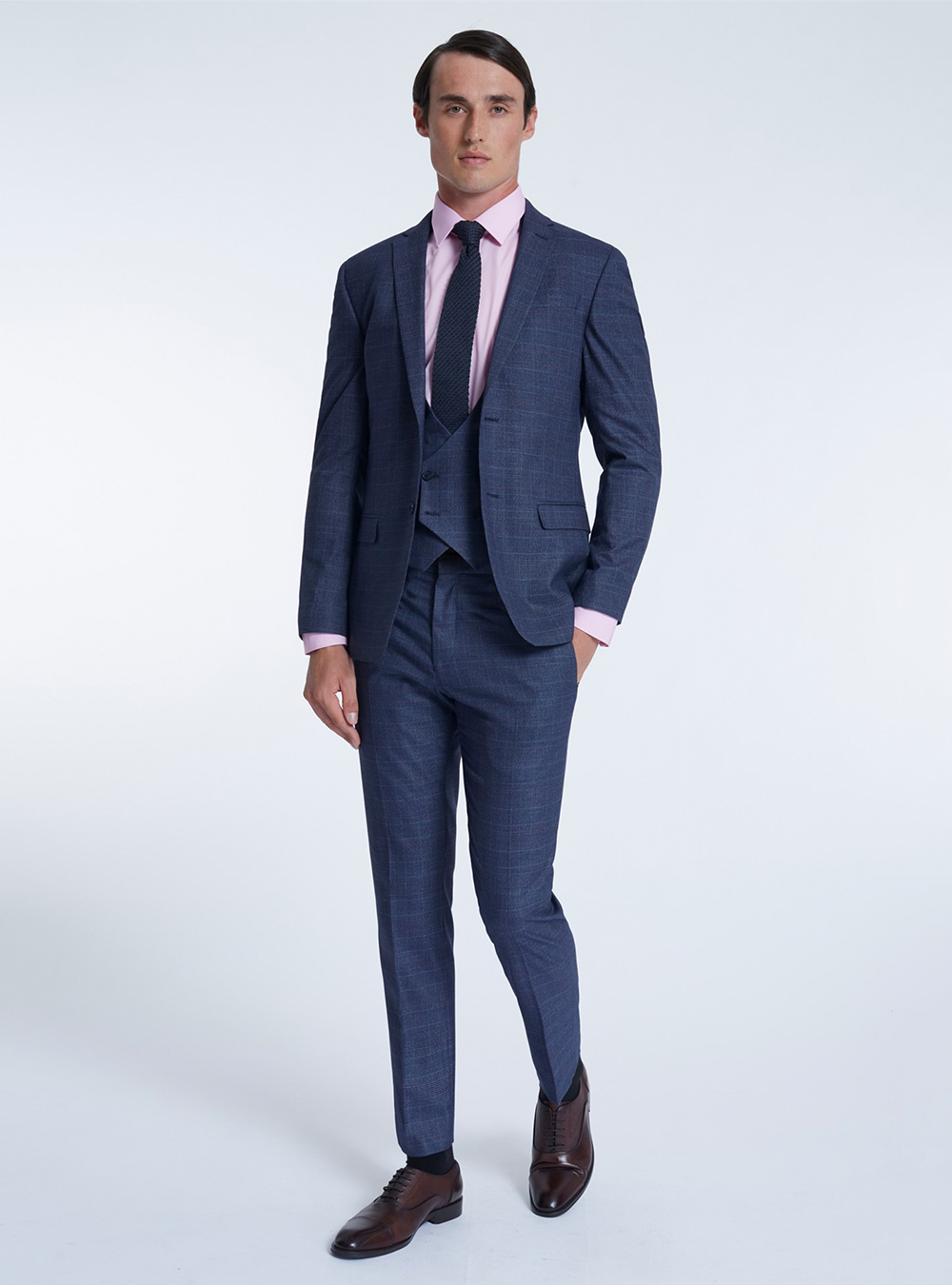 three-piece navy blue suit, pink shirt, and brown oxfords