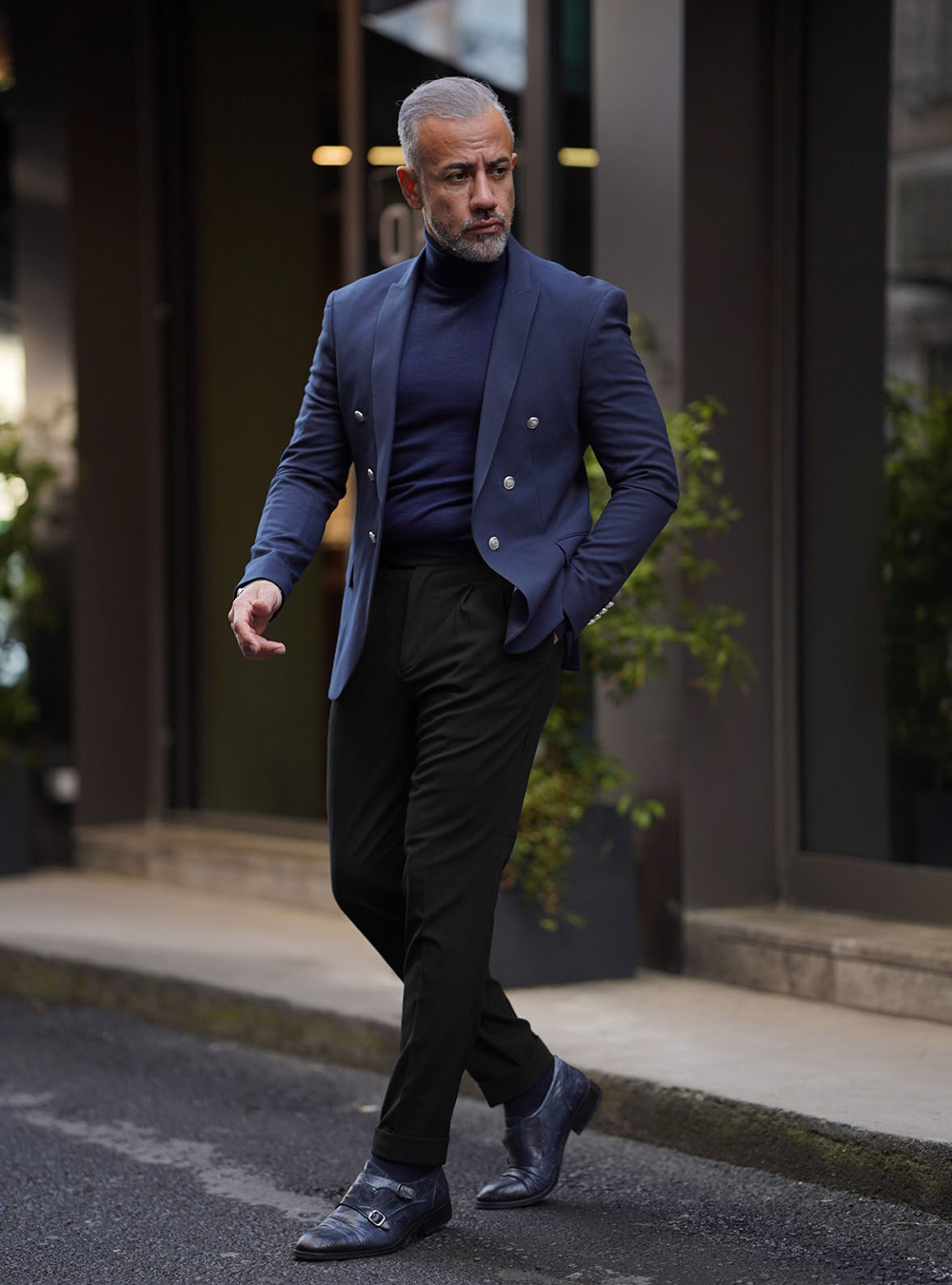 navy double-breasted blazer, navy turtleneck, black dress pants, and navy monk strap shoes