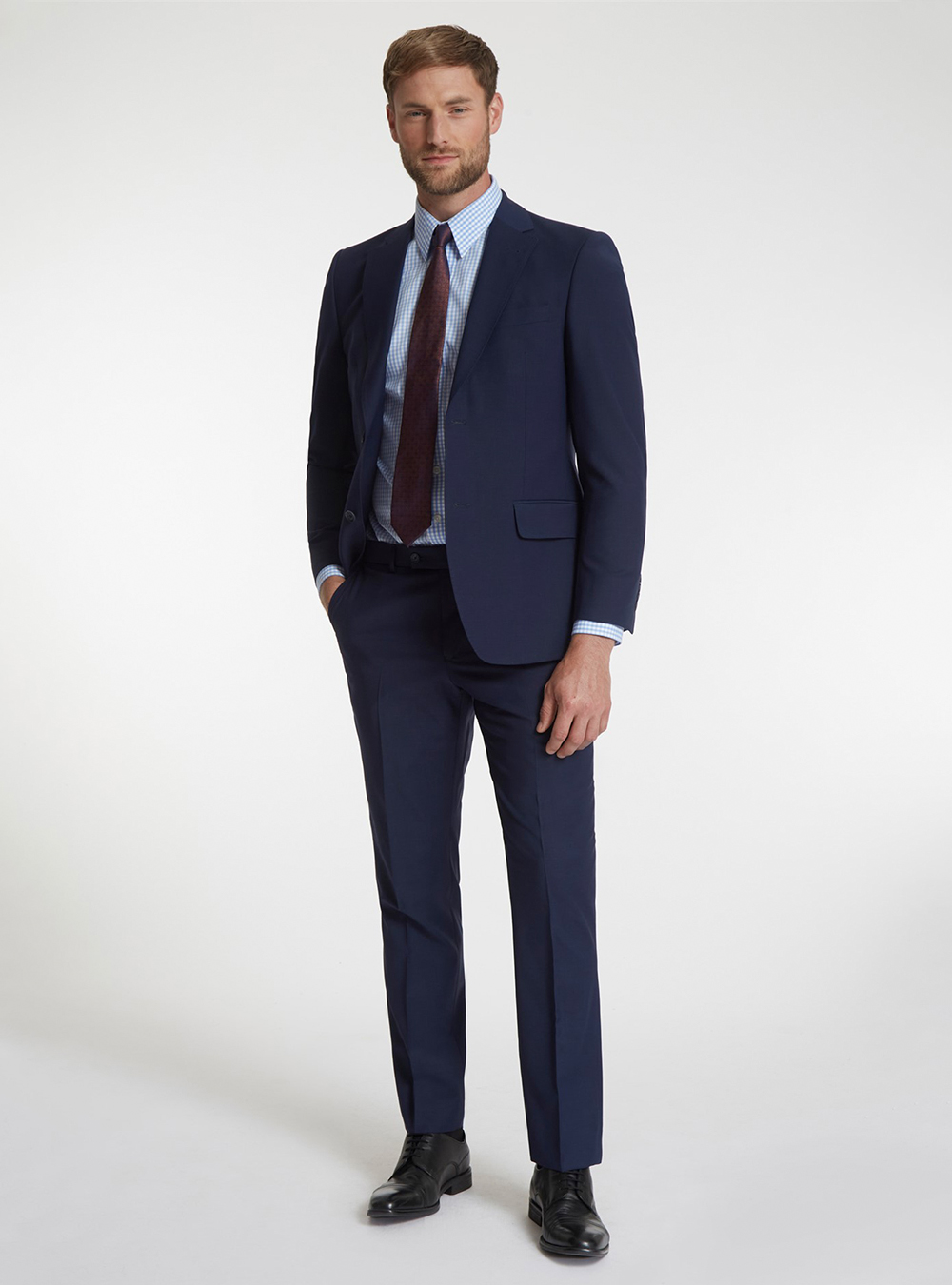navy suit, blue patterned shirt, and black derby shoes