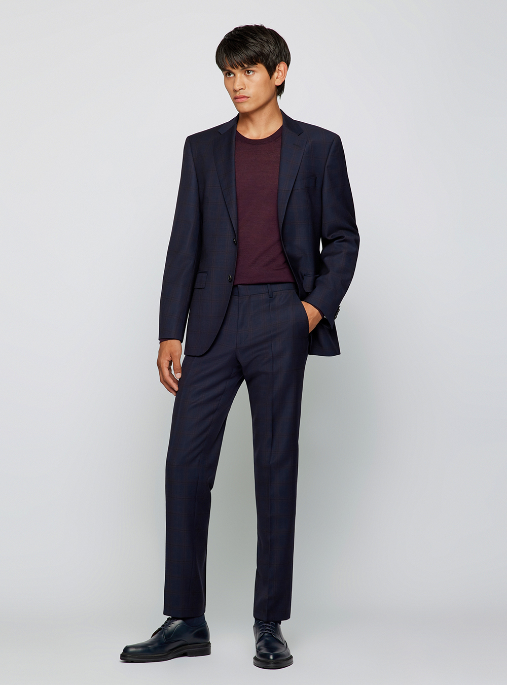 navy suit, burgundy crew-neck sweater, and black derby shoes