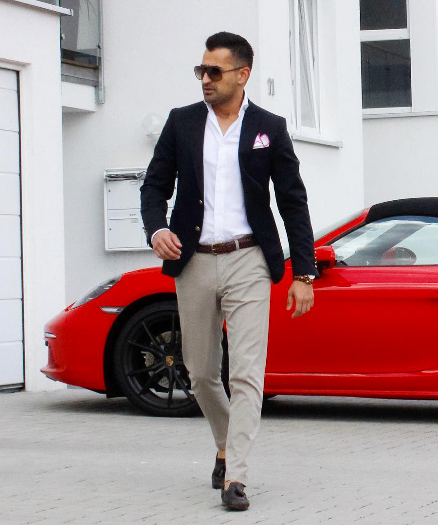 navy suit jacket, grey chinos, white dress shirt, and brown loafers