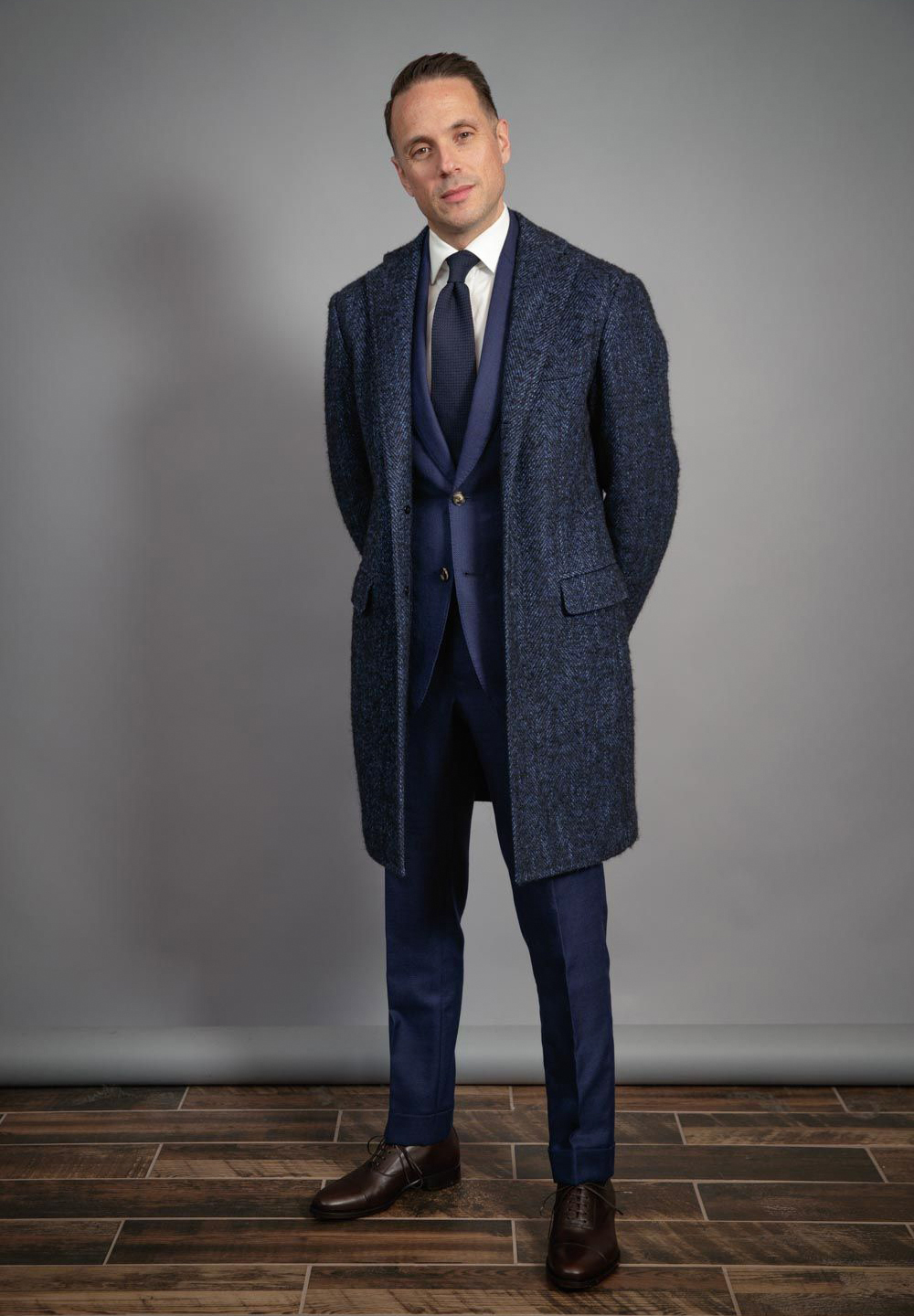 navy suit, navy overcoat, and brown shoes