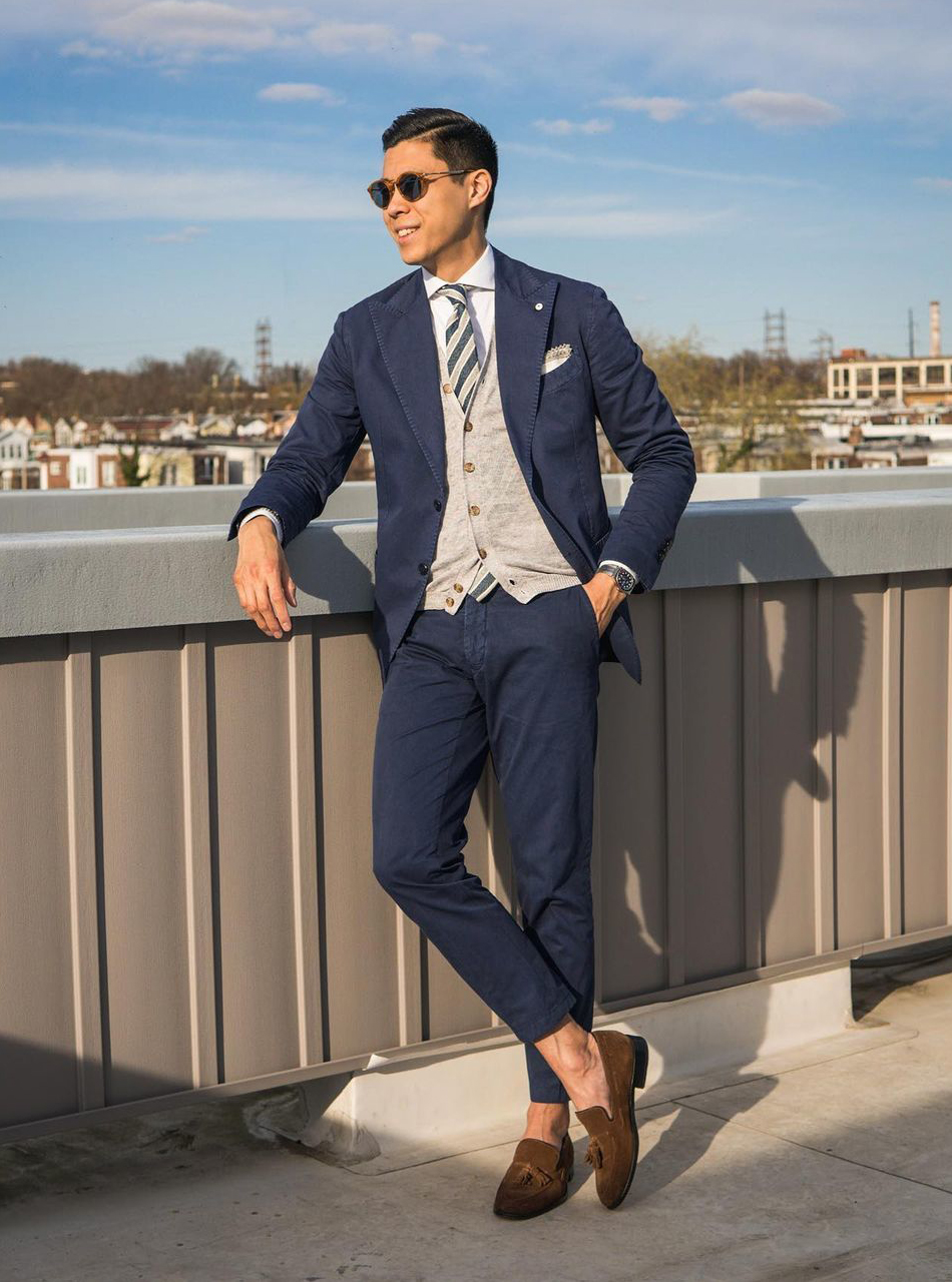 navy suit with a tan cardigan over a white shirt