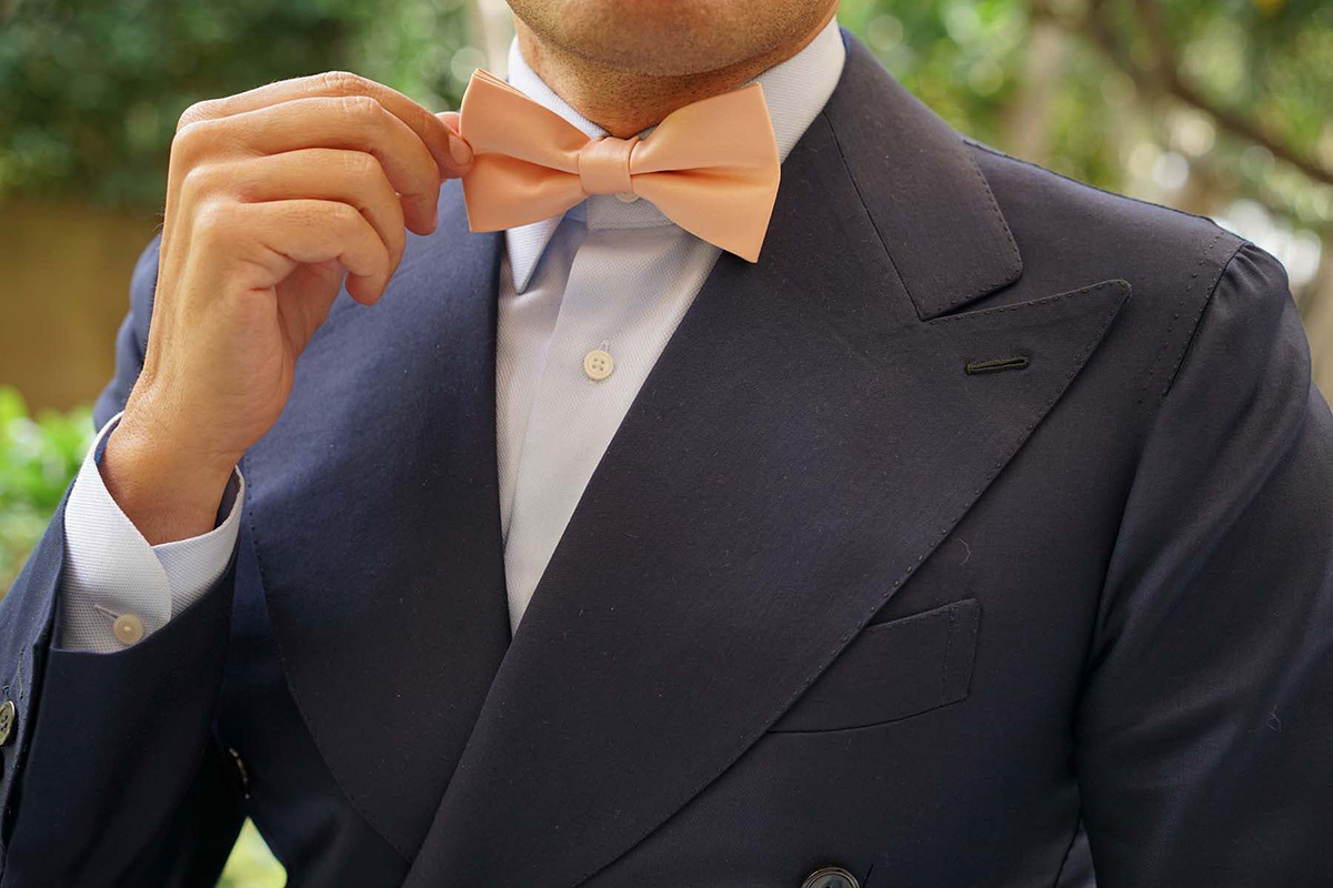 navy suit with light blue shirt and salmon bow tie