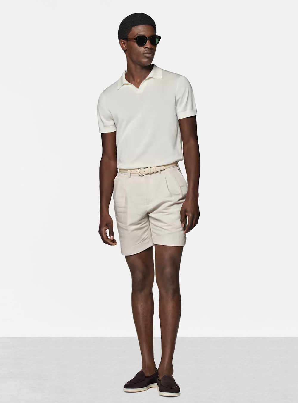 off-white polo shirt, beige shorts, and brown loafers
