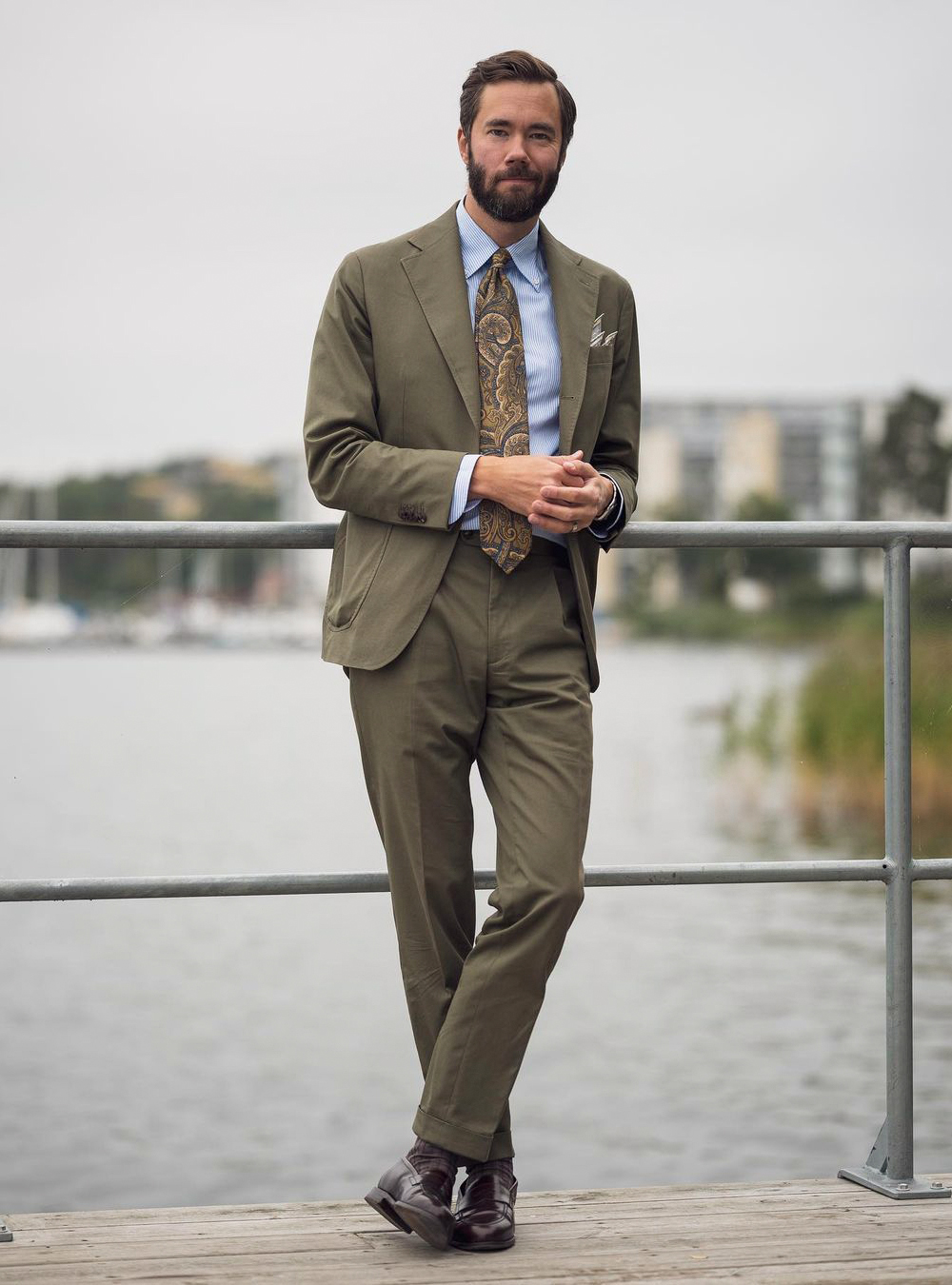 olive green suit, blue shirt, brown paisley tie, and brown loafers