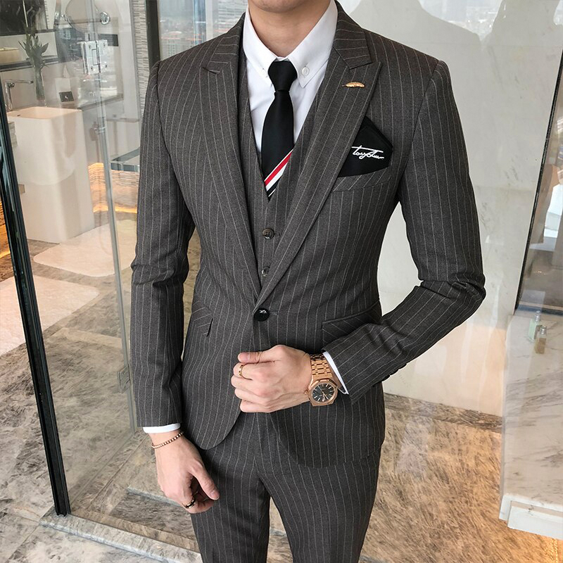 wearing button-down white shirt with black tie and grey three-piece pinstripe suit