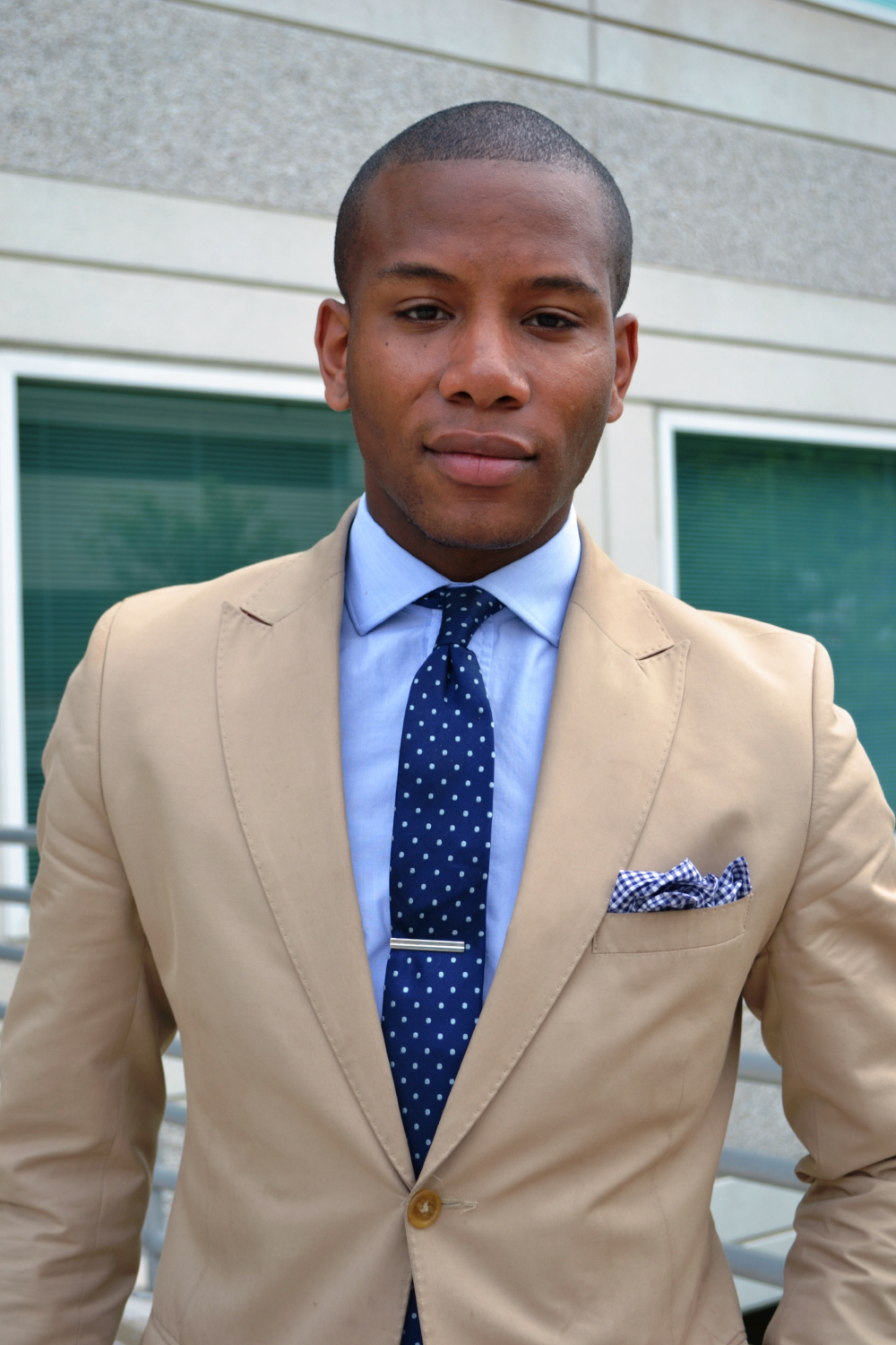 Tan suit, blue shirt, and dotted navy tie