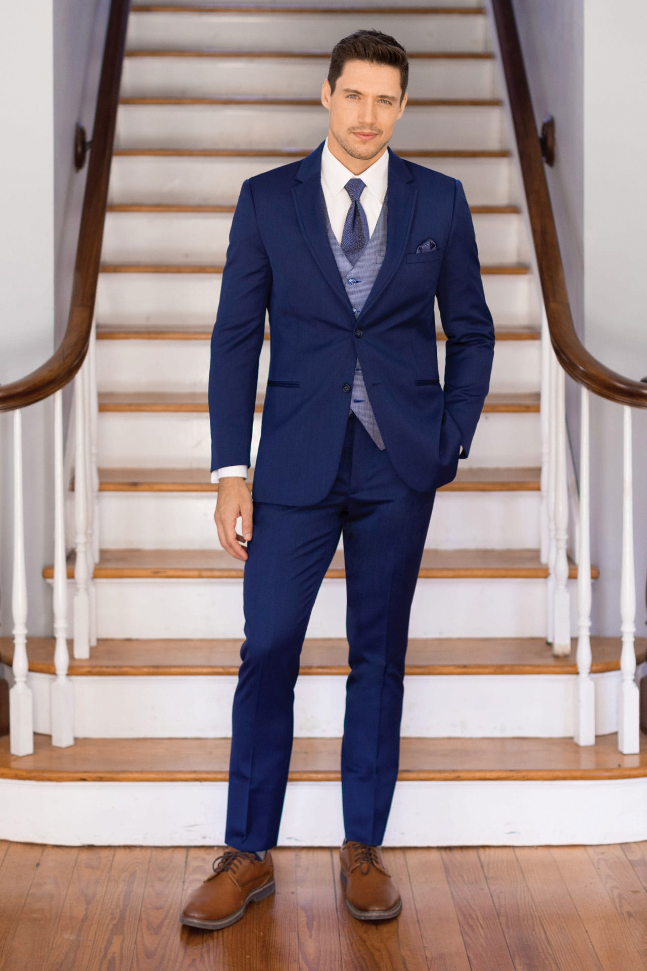 three-piece blue wedding suit, white shirt, blue tie, and brown derby shoes