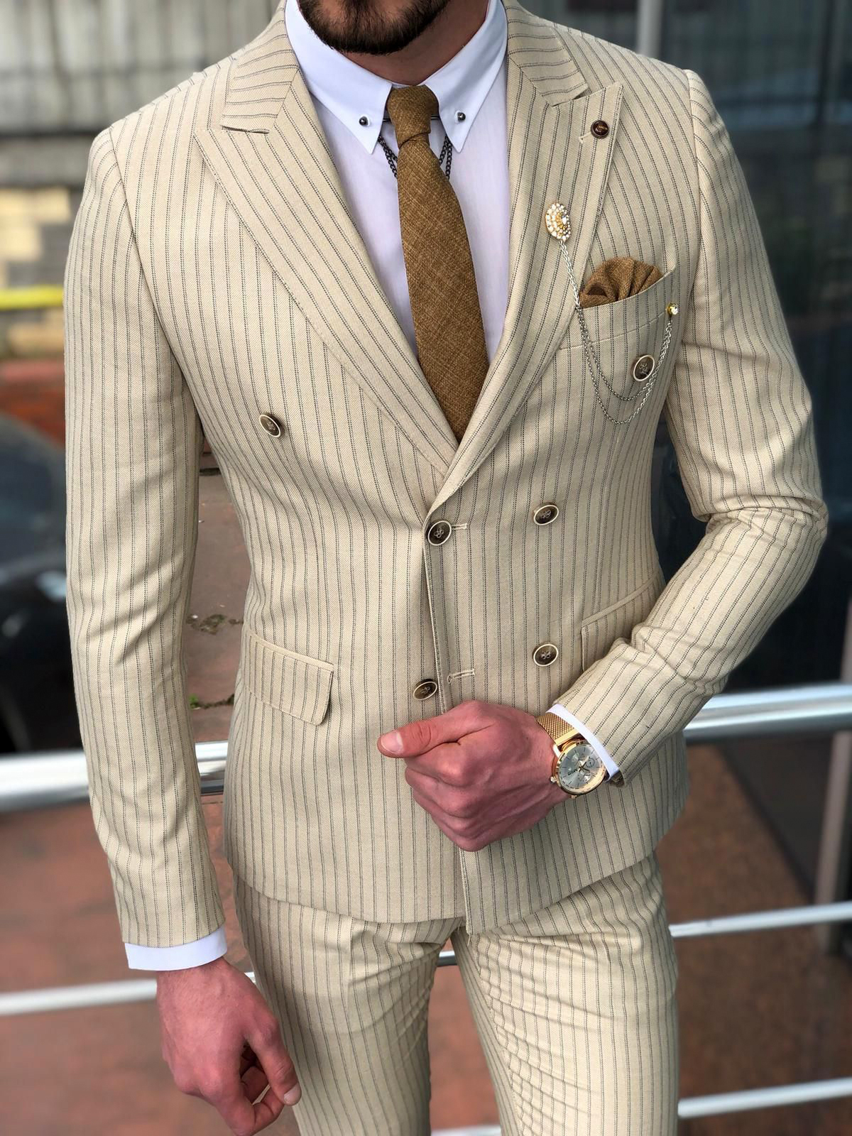 wearing beige pinstripe suit with a white dress shirt and bronze tie