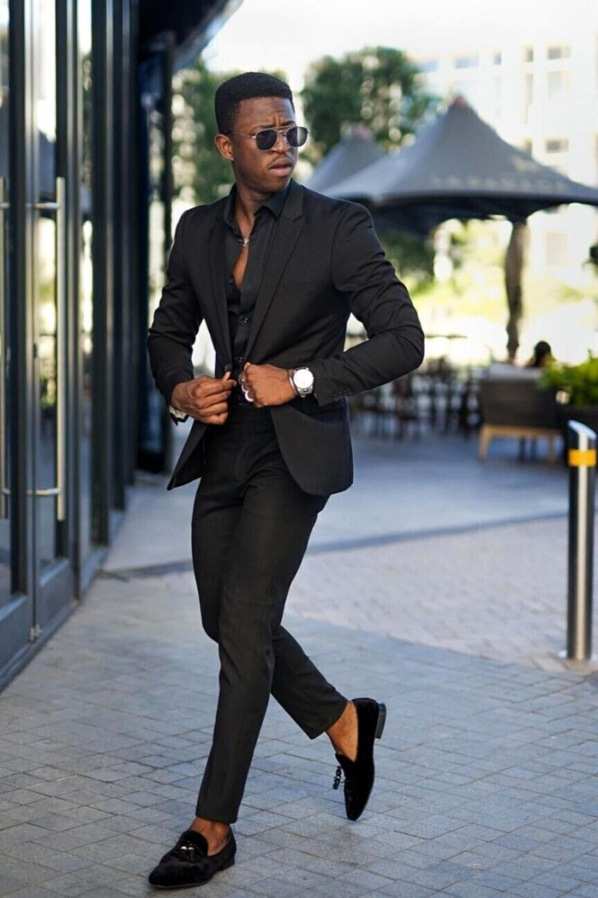 wearing black suit, black shirt, and black loafers at a wedding