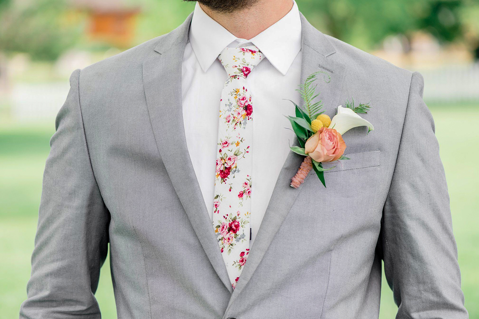 wearing a gray suit with white dress shirt and floral tie