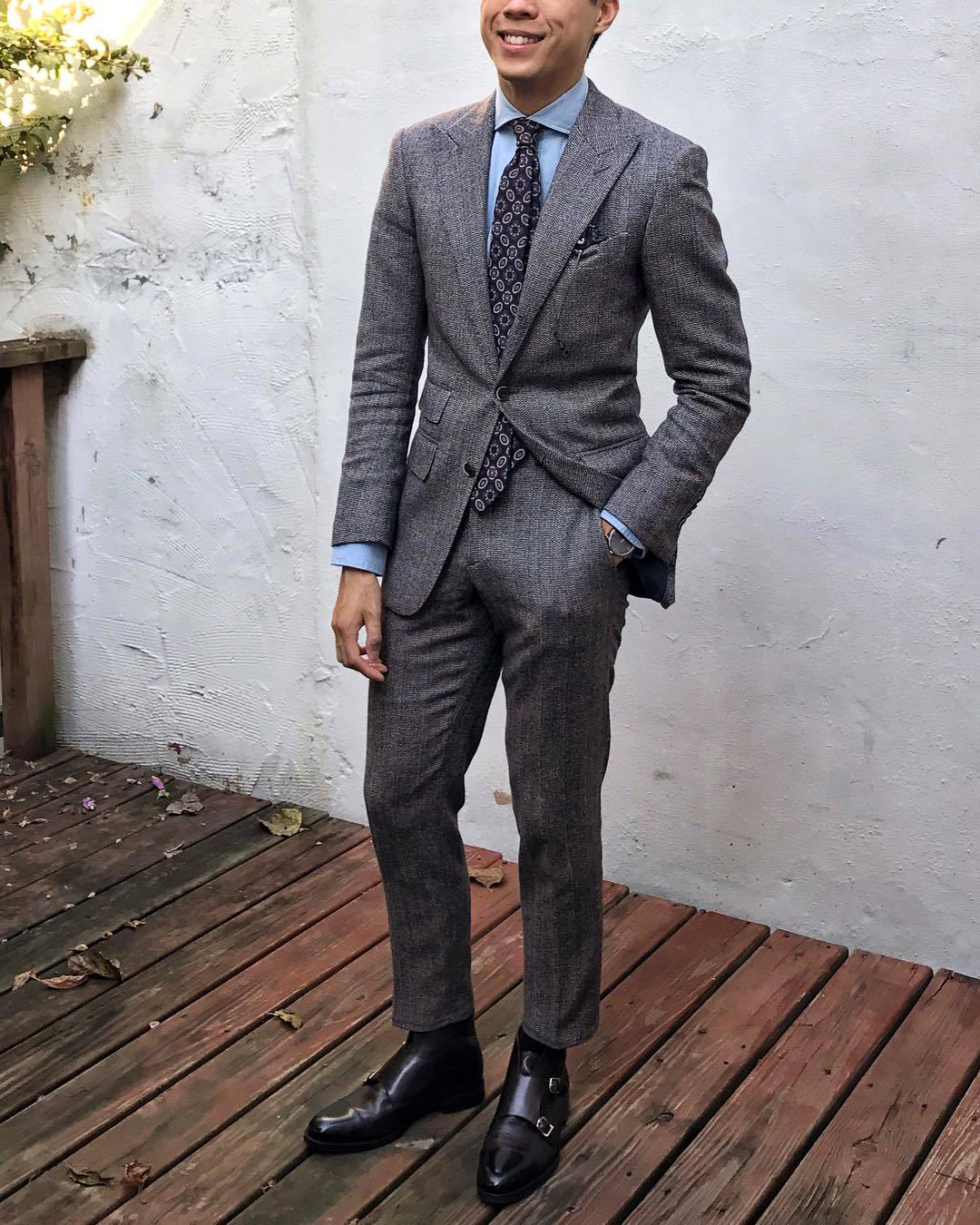 grey suit with blue shirt and black monk strap boots