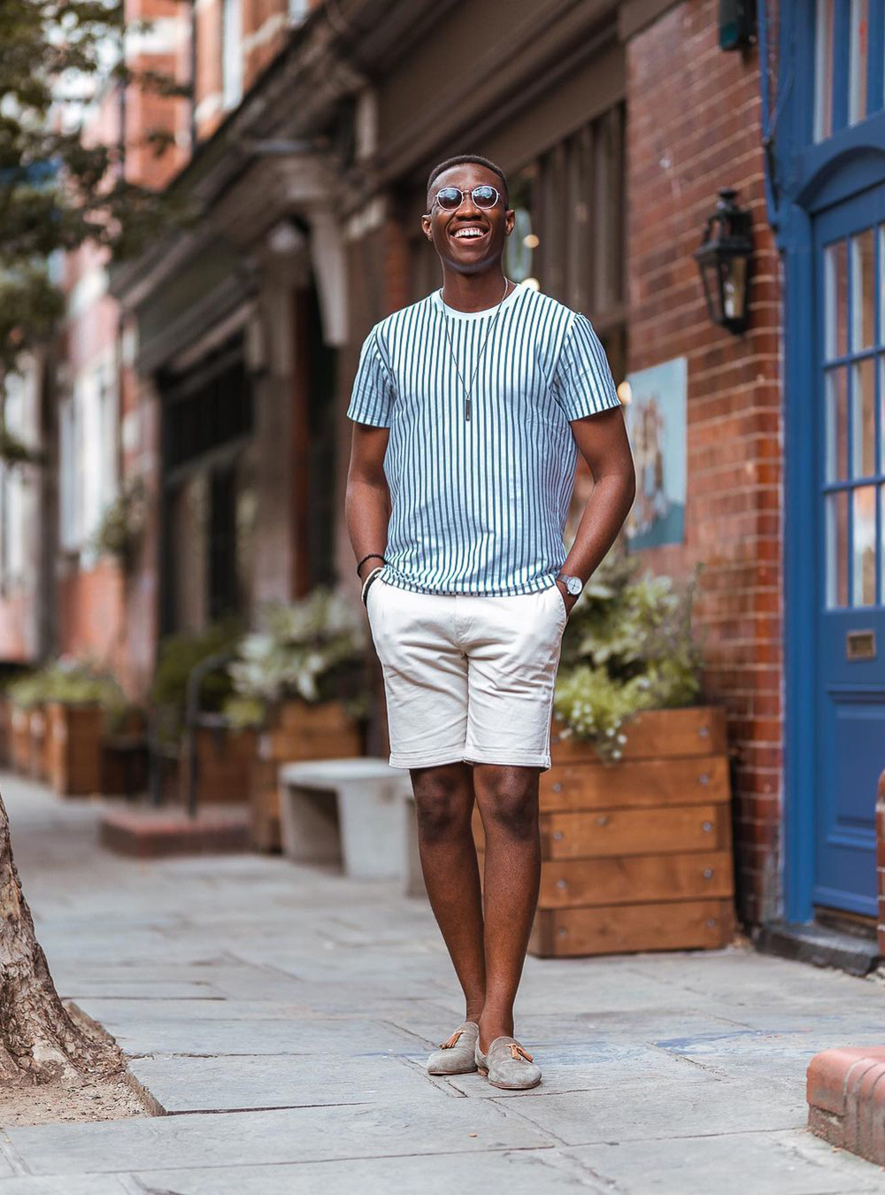 white/blue t-shirt, beige shorts, and tan loafers with no-show socks