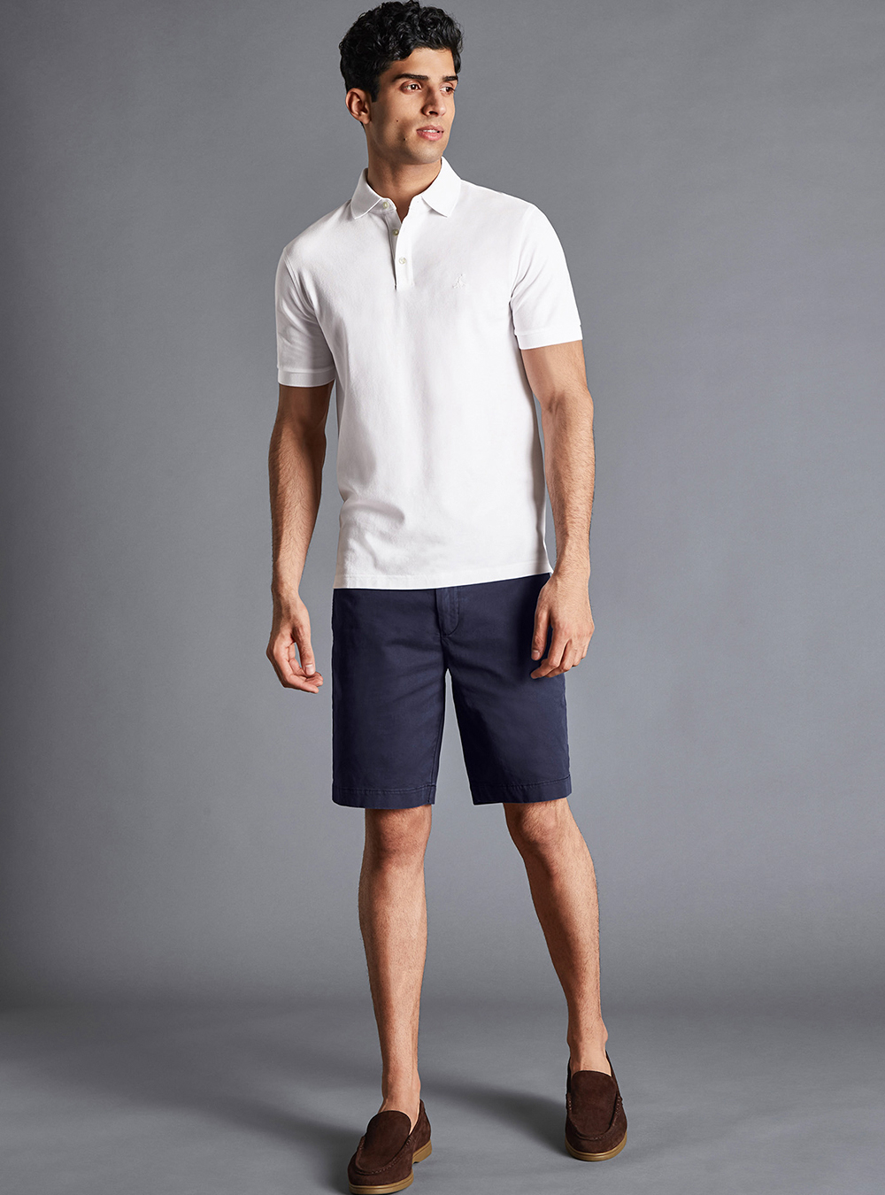 white polo t-shirt, navy dress shorts, and brown suede loafers