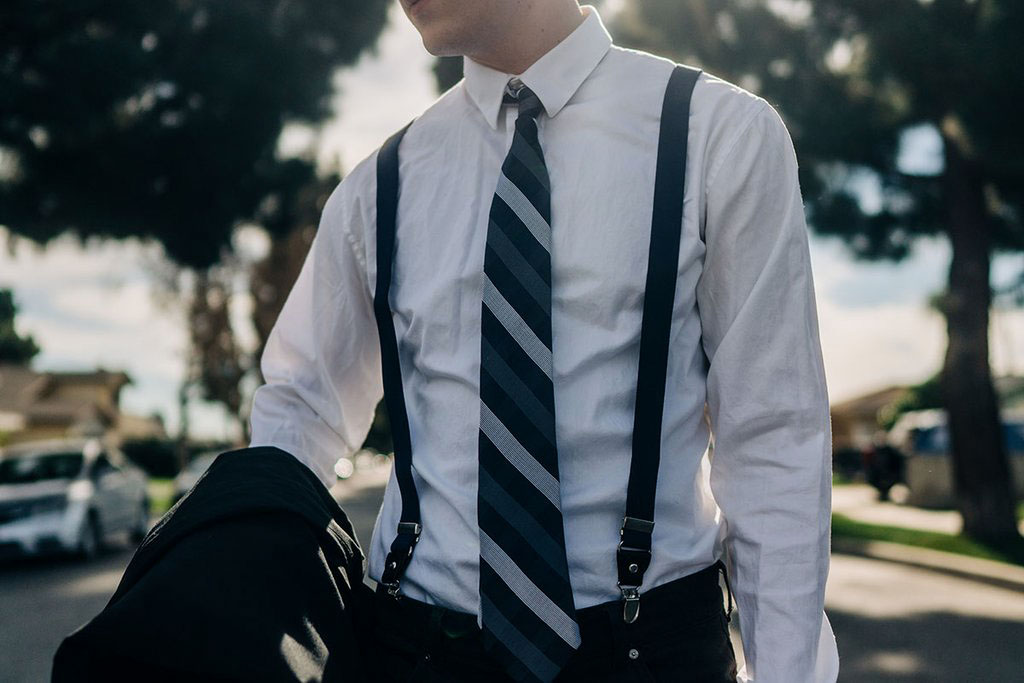 white shirt, patterned tie and black suspenders